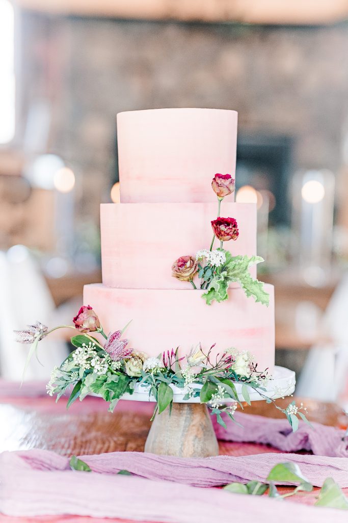 pink cake with flowers on cake stand