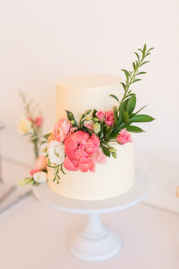 white modern cake with peony and spring flowers