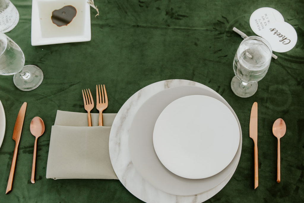 celestial plates with marble charger and green tablecloth